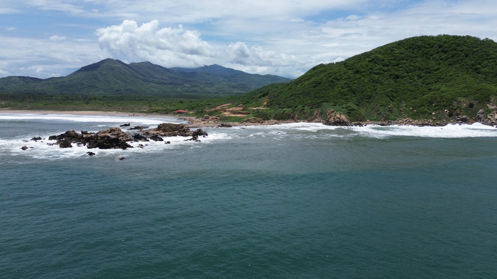 Vista costera de Tlacoyunque con aguas turquesas y montañas verdes